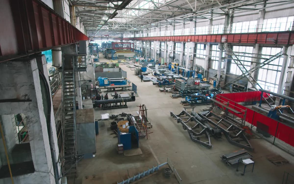 A long factory floor of fabrication equipment under skylights